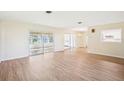 Spacious living room showcasing wood floors, neutral paint, and sliding glass doors at 1841 5Th Se St, Winter Haven, FL 33880