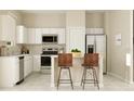 Bright kitchen features white cabinets, stainless steel appliances, and bar seating at 2618 Skyline Loop, Kissimmee, FL 34758