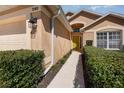 Inviting home exterior with a well-manicured lawn, manicured hedges, and bright yellow front door at 540 Buckingham Cir, Davenport, FL 33897