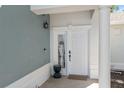 Close-up of the front door with a white frame, elegant columns, and a 'Welcome' mat on the tiled porch at 7636 Heritage Crossing Way, Reunion, FL 34747