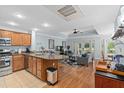 Open-concept kitchen and living room featuring wood cabinets, granite countertops, stainless steel appliances, and a ceiling fan at 7636 Heritage Crossing Way, Reunion, FL 34747