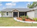 Inviting home entrance featuring a stone accent wall and beautifully landscaped garden at 2155 Thompson Rd, Bartow, FL 33830