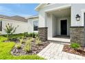 Inviting front entrance with stone pillars, manicured landscaping, and a paved walkway to the front door at 5774 Greenery Ln, St Cloud, FL 34771