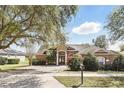 Single Gathering home featuring a brick driveway, a mailbox, landscaping, and a large tree at 1372 Madison Ivy Cir, Apopka, FL 32712