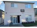 Rear exterior of the house featuring a basketball hoop, sliding door, and a fenced backyard at 14417 Jasmine Glen Dr, Orlando, FL 32824