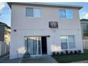 Back of home features a sliding glass door, a basketball hoop, and small landscaping at 14417 Jasmine Glen Dr, Orlando, FL 32824