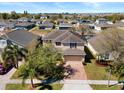 A charming two-story home with a brick driveway and a well-manicured lawn, nestled in a friendly neighborhood at 754 Andalusia Loop, Davenport, FL 33837