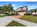 Two-story home with a brick driveway, attached two-car garage, and well-maintained landscaping in a suburban setting at 754 Andalusia Loop, Davenport, FL 33837