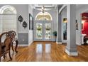 Grand foyer with hardwood floors, decorative columns, arched doorways, and an abundance of natural light at 867 Hanover Way, Lakeland, FL 33813
