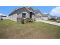 Charming single-story home with gray stucco, stone accents, and a well-manicured lawn at 7066 Victoria Rd, Lakeland, FL 33809