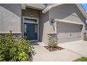 Close up of a charming home's front door, stone accents, and a two-car garage at 7066 Victoria Rd, Lakeland, FL 33809
