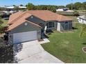 Aerial view of a well-kept single-story home with a spacious yard and a long driveway leading to a two-car garage at 1112 View Pointe Cir, Lake Wales, FL 33853