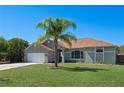 Well-maintained single-story home with a lush green lawn and mature palm tree, presenting an inviting exterior at 1112 View Pointe Cir, Lake Wales, FL 33853