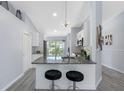 Modern kitchen featuring granite countertops, a stylish lighting fixture and seating at the bar at 3548 Galloway Oaks Ct, Lakeland, FL 33810