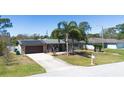 Inviting single-story home with solar panels, a driveway, a well-manicured lawn, and a cozy front porch with rocking chairs at 1062 Mayflower Ave, Deltona, FL 32725