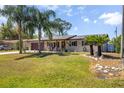 Charming single-story home with a well-manicured lawn, palm trees, and a cozy front porch with rocking chairs at 1062 Mayflower Ave, Deltona, FL 32725