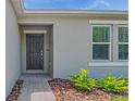 Close-up of the home's entry featuring decorative landscaping and a modern black front door at 140 Jones Fish Camp Rd, Edgewater, FL 32141
