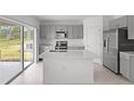 Contemporary kitchen boasts stainless steel appliances, an island, and modern gray cabinets at 140 Jones Fish Camp Rd, Edgewater, FL 32141