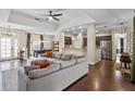 Open-concept living room with hardwood floors, ceiling fan, and seamless flow to kitchen and dining at 3688 Hurlbut Cir, Lake Wales, FL 33898