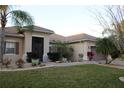 Beautiful home featuring a well-manicured lawn, tropical plants, and a tile roof at 4002 Bougainvillea Pl, Kissimmee, FL 34746
