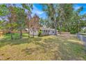 Charming home with lush green lawn, mature trees, and a fenced yard at 2415 Sutton Rd, Lakeland, FL 33810