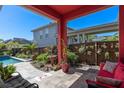 A covered patio with comfortable seating and views of the beautifully landscaped yard at 9170 Tavistock Lakes Blvd, Orlando, FL 32827