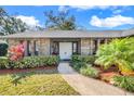 Inviting front entrance of the home features a double door entry framed with mature trees and manicured shrubbery at 282 Lake Griffin Cir, Casselberry, FL 32707