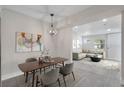 Open-concept dining area with modern lighting, stylish furniture, and seamless flow to the living room at 10301 Us Highway 27 # 26, Clermont, FL 34711