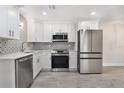 Modern kitchen with stainless steel appliances, white cabinets, and stylish backsplash at 10301 Us Highway 27 # 26, Clermont, FL 34711