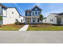 Charming two-story home with blue and gray accents, a welcoming front porch and professionally landscaped front yard at 3083 Voyager Ave, St Cloud, FL 34771