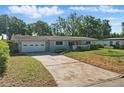 Charming single-story home featuring an attached garage and driveway with a landscaped front yard at 1005 Catalpa Ln, Orlando, FL 32806