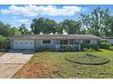 Charming single-story home with a well-manicured lawn, driveway and cozy front porch at 1005 Catalpa Ln, Orlando, FL 32806