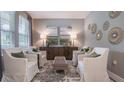 Cozy sitting area with four armchairs, a tufted ottoman, and stylish decor for a relaxing atmosphere at 1918 Clear Sky Dr, Kissimmee, FL 34744