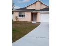Single-Gathering home featuring an attached garage and driveway with front yard landscaping at 602 Hillcrest Dr, Davenport, FL 33897