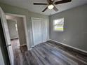 Bright bedroom with wood-look flooring, a double door closet and a ceiling fan at 1011 Old Lake Alfred Rd, Auburndale, FL 33823