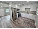 Modern kitchen featuring new stainless steel appliances, granite countertops, and white cabinetry at 1011 Old Lake Alfred Rd, Auburndale, FL 33823