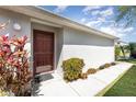 Inviting front entrance with a storm door and lush landscaping at 2076 Whispering Trails Blvd, Winter Haven, FL 33884