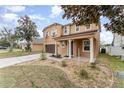 Two-story home with front yard landscaping, covered entrance, and a two-car garage at 265 Elderberry Dr, Davenport, FL 33897
