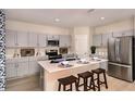 Modern kitchen featuring stainless steel appliances, gray cabinets, and a center island with seating at 1780 Frogmore Ave, Haines City, FL 33844