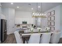 Bright dining area with modern chandelier, table with 6 chairs, and seamless flow into a white kitchen at 1018 Brimstone Cir, Winter Haven, FL 33884