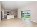 Open-concept living space featuring light wood floors, neutral walls and access to the patio through sliding glass doors at 1026 Foreshore Ln, Haines City, FL 33844
