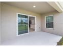 Covered patio with sliding glass door access to the interior, offering space for outdoor relaxation at 1026 Foreshore Ln, Haines City, FL 33844