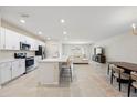 Bright and airy kitchen featuring white cabinets, stainless steel appliances, and an island with seating at 2047 Rosewood Cir, Lakeland, FL 33810