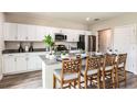 Modern kitchen with white cabinets, stainless steel appliances, an island with counter seating, and hard surface countertops at 3814 Geranium Ave, Lake Hamilton, FL 33851