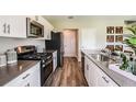 Well-appointed kitchen featuring stainless steel appliances, white cabinets, hard surface countertops, and wood-look flooring at 3814 Geranium Ave, Lake Hamilton, FL 33851