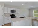 Modern kitchen with white cabinets, stainless steel appliances, and an island at 1538 Sage Ave, Haines City, FL 33844