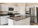 Modern kitchen featuring stainless steel appliances, white cabinets, and a center island with a sink at 1542 Sage Ave, Haines City, FL 33844