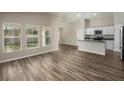 Spacious living room with hardwood floors, bright windows, and open layout leading to the kitchen at 1542 Sage Ave, Haines City, FL 33844