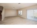 Spacious living room with wood floors, a sliding glass door, and natural light from the windows at 1554 Sage Ave, Haines City, FL 33844