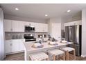 Open kitchen with stainless steel appliances, quartz countertops and modern barstool seating at 1562 Sage Ave, Haines City, FL 33844